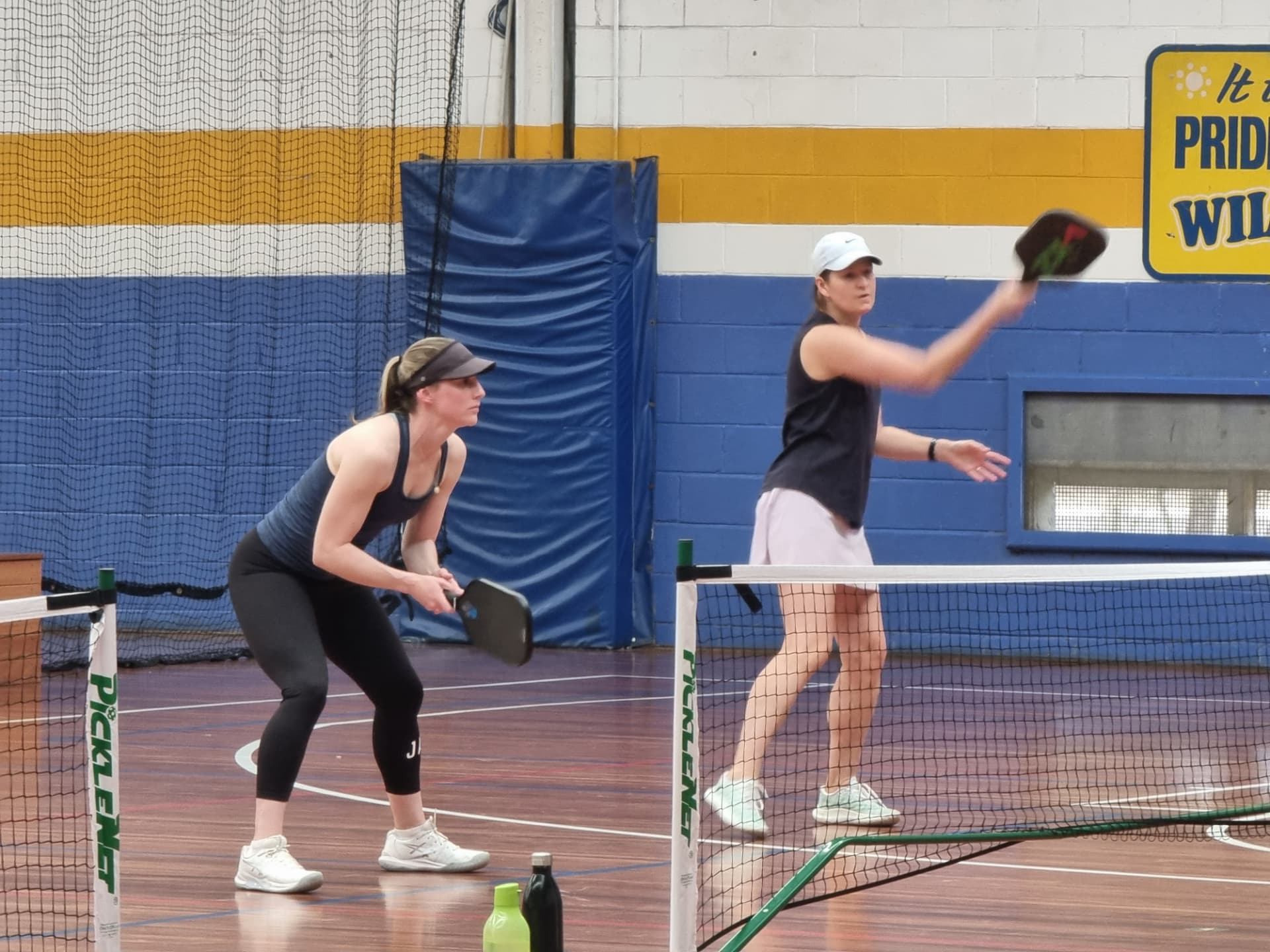 Two members mid-rally during an indoor social session
