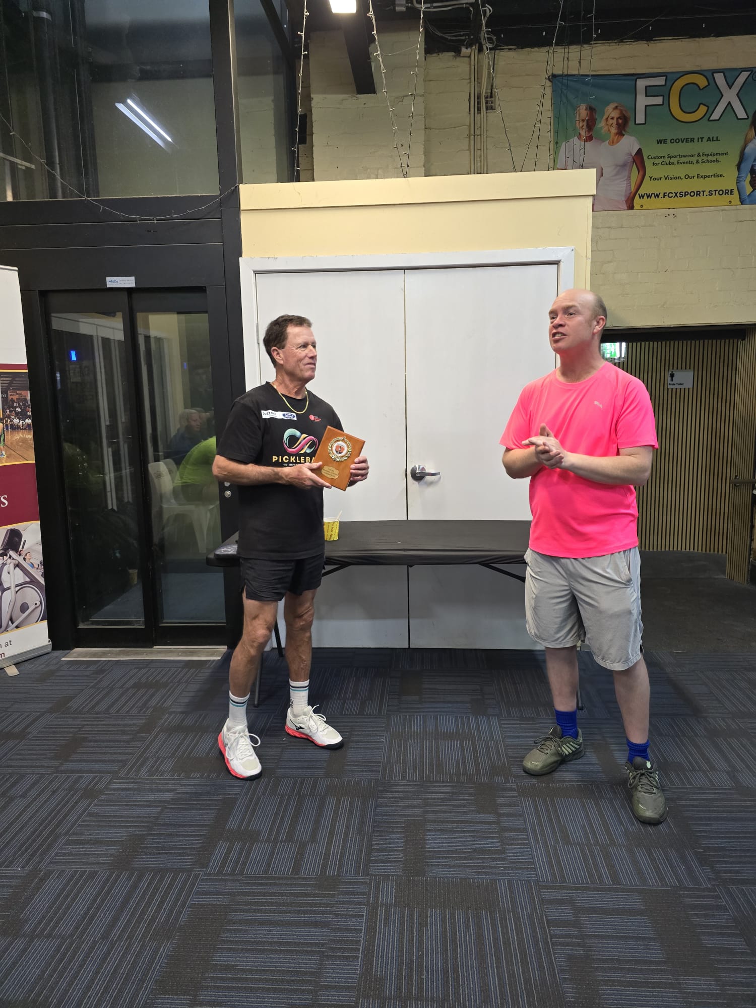 A member receiving a trophy from the club at an indoor presentation