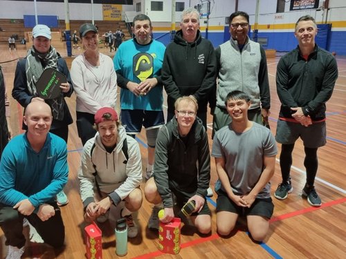 Club members and friends gathered together courtside after a social session